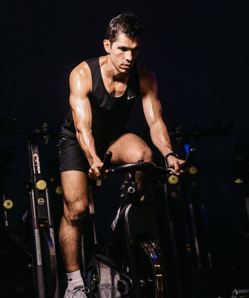 A focused man performing a core strength exercise in a dark gym.